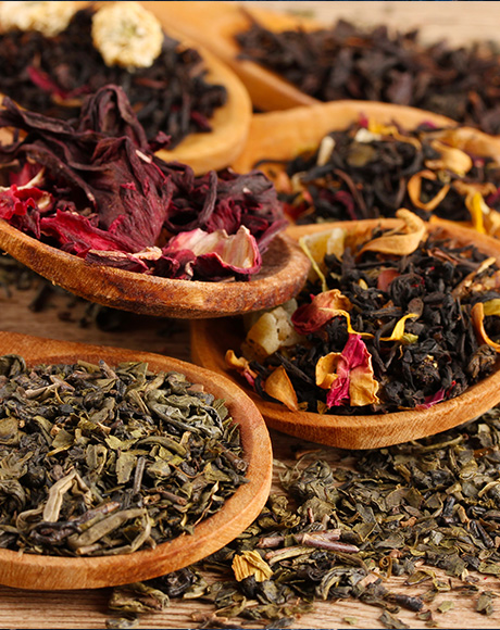 a selection of loose leaf teas on wooden spoons