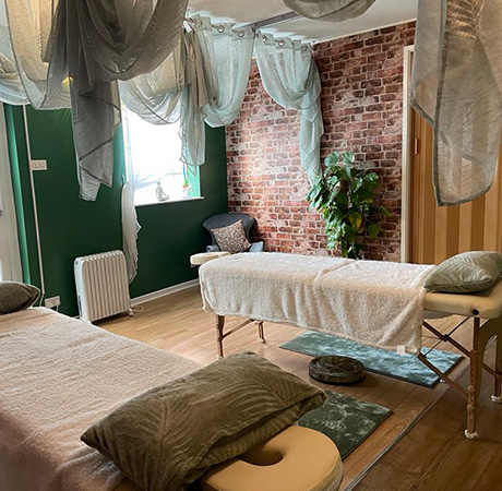 spa treatment room with two massage tables and calming decor featuring soft textiles and greenery perfect for relaxation and wellness 7 benefits of massage therapy